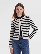 Woman wearing black and white striped cardigan and jeans